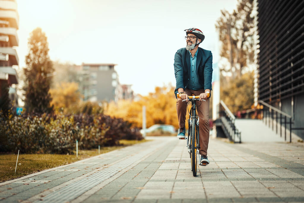 Colaborador sorridente e alegre utilizando auxílio-mobilidade em bicicleta por aluguel
